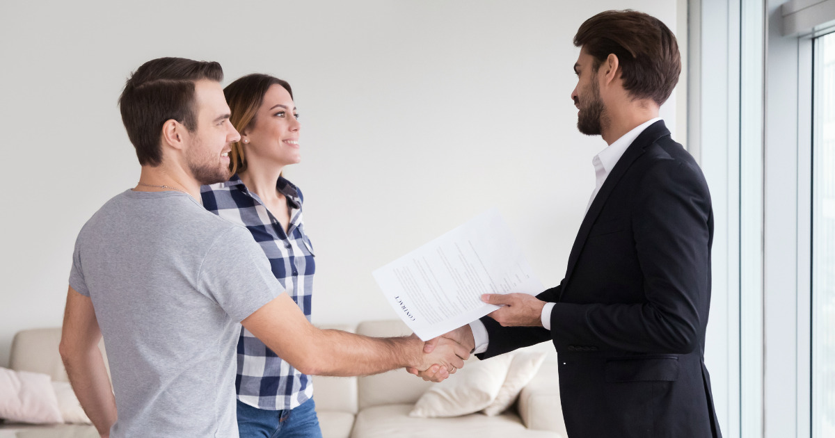 A couple shakes hand with a Property Manager committing to rent the apartment they just toured.